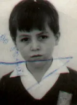 Old black and white school photo of a young boy with a serious expression